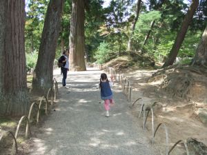 真由喜が庭園の細道で一つ足で跳ねる