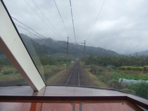 電車の後ろの窓から山を見る